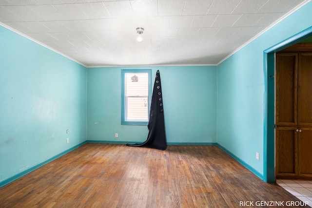 unfurnished room with hardwood / wood-style floors and crown molding