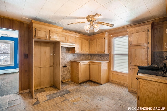 kitchen featuring light parquet floors, wooden walls, and ceiling fan