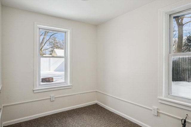 carpeted empty room featuring baseboards and a healthy amount of sunlight