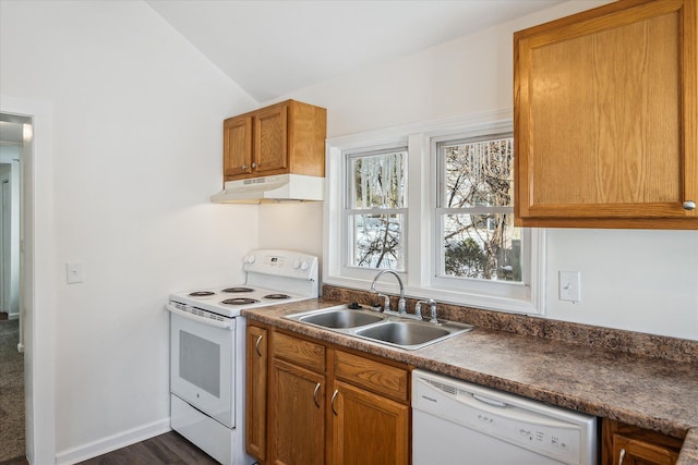 kitchen with under cabinet range hood, white appliances, a sink, vaulted ceiling, and dark countertops