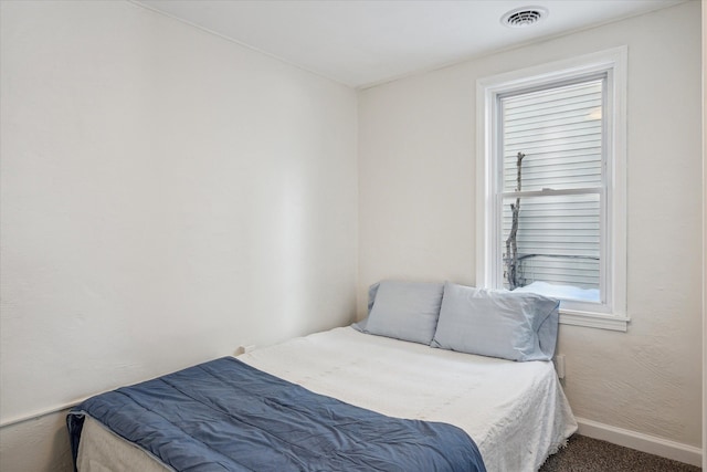 carpeted bedroom with visible vents and baseboards