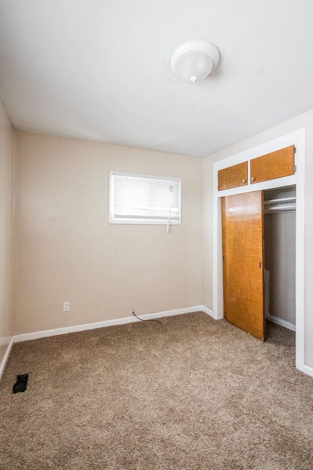 unfurnished bedroom with carpet and a closet