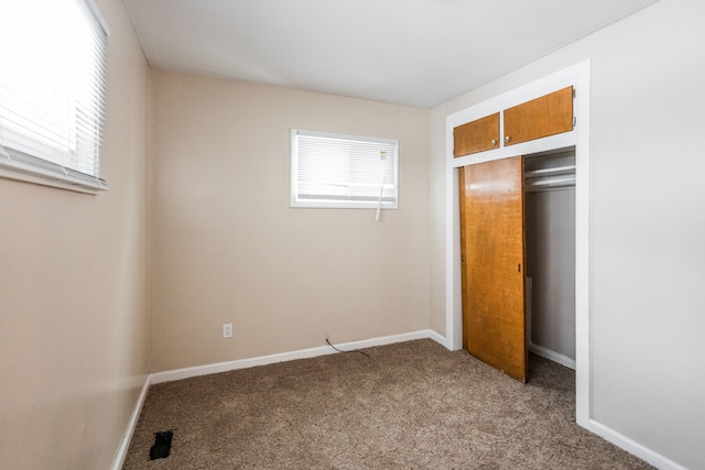 unfurnished bedroom with a closet and light colored carpet