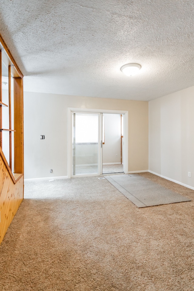 spare room featuring carpet floors and a textured ceiling