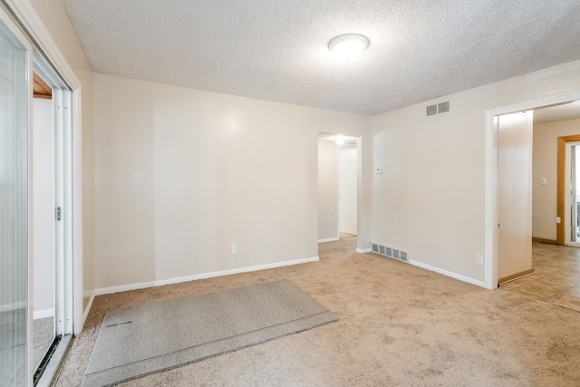 carpeted spare room with a textured ceiling