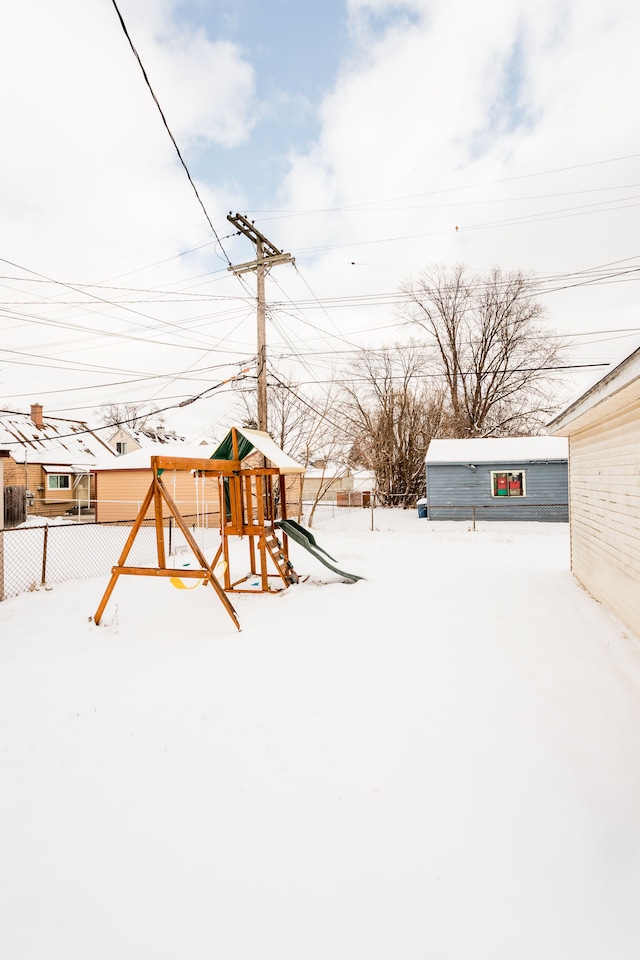 yard layered in snow featuring a playground