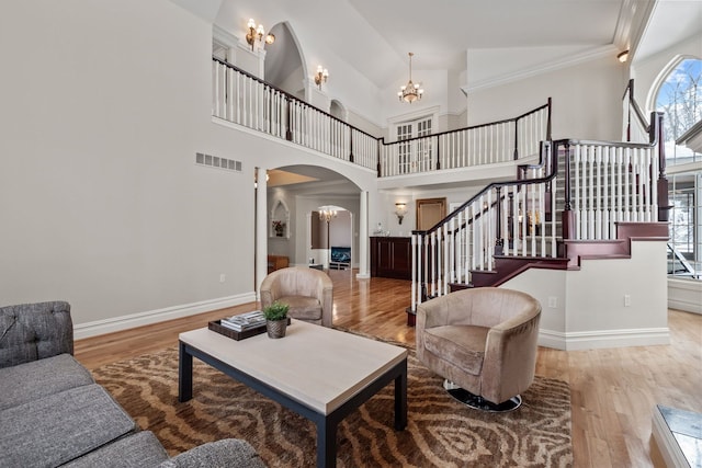 6705 College Park, Clarkston, MI 48346 - living room featuring visible vents, arched walkways, a chandelier, stairway, and wood finished floors
