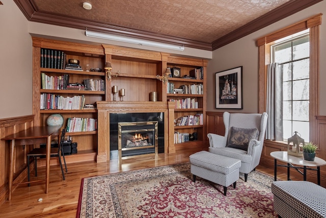 6705 College Park, Clarkston, MI 48346 - sitting room with crown molding, a glass covered fireplace, wainscoting, and wood finished floors