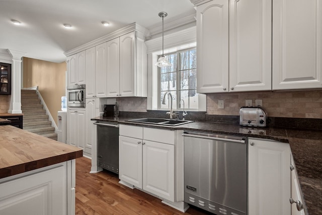 6705 College Park, Clarkston, MI 48346 - kitchen featuring wood counters, backsplash, appliances with stainless steel finishes, decorative columns, and a sink