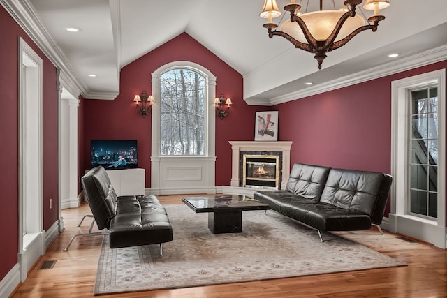 6705 College Park, Clarkston, MI 48346 - living area with a notable chandelier, vaulted ceiling, a fireplace, visible vents, and light wood finished floors