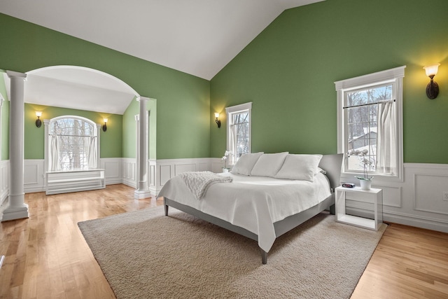 6705 College Park, Clarkston, MI 48346 - bedroom with high vaulted ceiling, decorative columns, arched walkways, wainscoting, and light wood finished floors