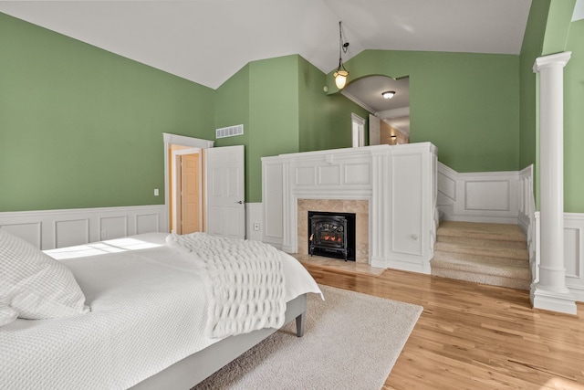 6705 College Park, Clarkston, MI 48346 - bedroom with high vaulted ceiling, decorative columns, visible vents, a wainscoted wall, and light wood finished floors