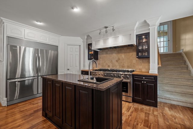 6705 College Park, Clarkston, MI 48346 - kitchen with decorative columns, decorative backsplash, stainless steel appliances, light wood finished floors, and a sink