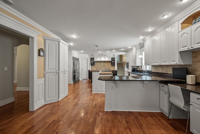 6705 College Park, Clarkston, MI 48346 - kitchen featuring tasteful backsplash, stainless steel fridge, a peninsula, white cabinets, and a sink