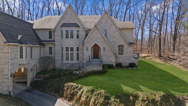 6705 College Park, Clarkston, MI 48346 - view of front facade with a front yard, stone siding, and a shingled roof