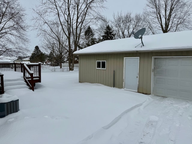 yard layered in snow with a garage and a deck