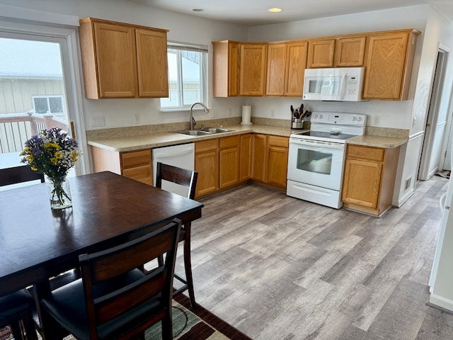 kitchen with sink, white appliances, and light hardwood / wood-style flooring