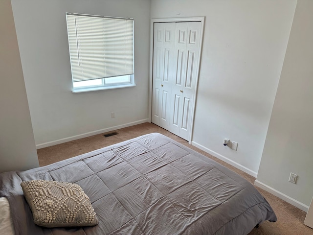 bedroom with light colored carpet and a closet