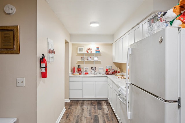 kitchen featuring white appliances, white cabinetry, light countertops, and a sink