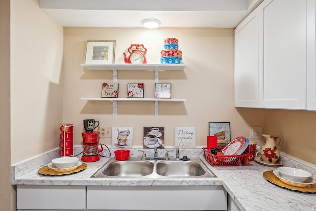 kitchen featuring light countertops, open shelves, a sink, and white cabinets