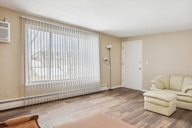 living room with baseboards, a baseboard heating unit, wood finished floors, and an AC wall unit