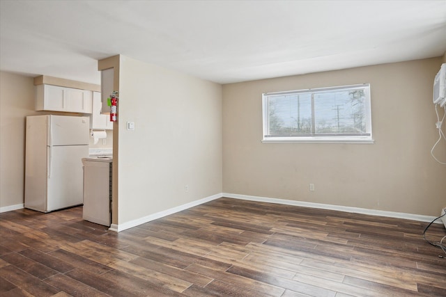 spare room featuring dark wood-style floors and baseboards