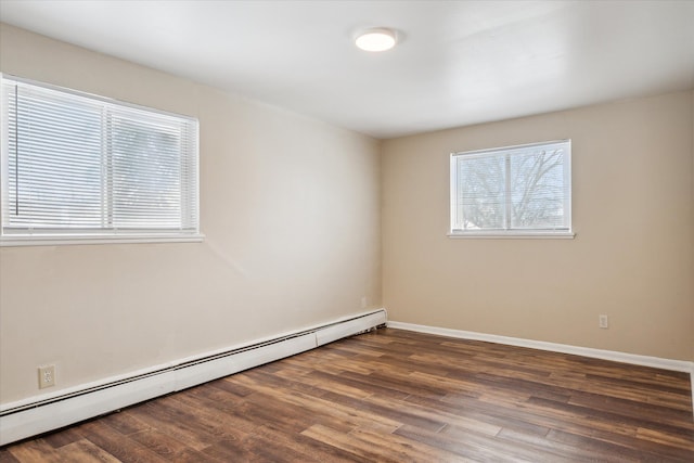 unfurnished room with a baseboard heating unit, dark wood-type flooring, and baseboards