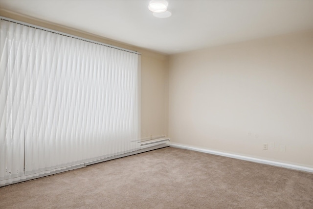 spare room featuring light carpet, baseboards, and baseboard heating