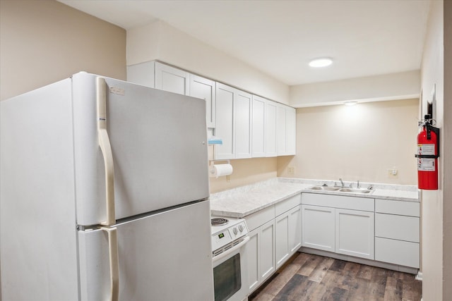 kitchen with dark wood-style floors, white appliances, white cabinetry, and a sink