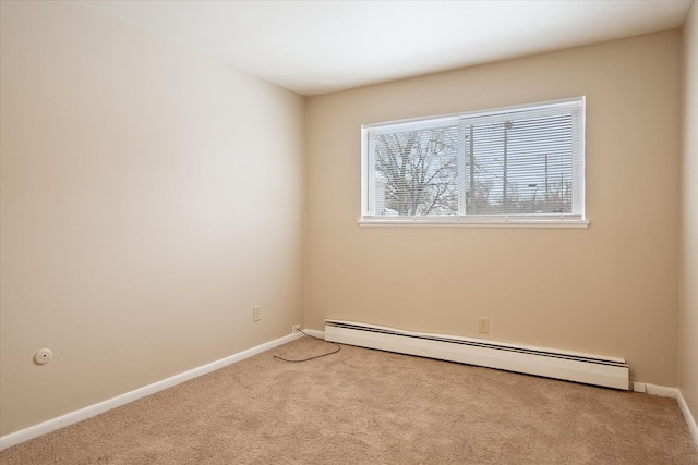 spare room with a baseboard heating unit, light carpet, and baseboards