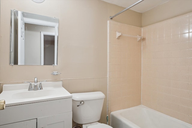 bathroom with shower / washtub combination, wainscoting, vanity, and toilet