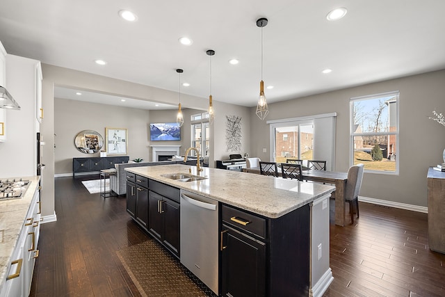 kitchen featuring sink, stainless steel appliances, light stone countertops, and hanging light fixtures