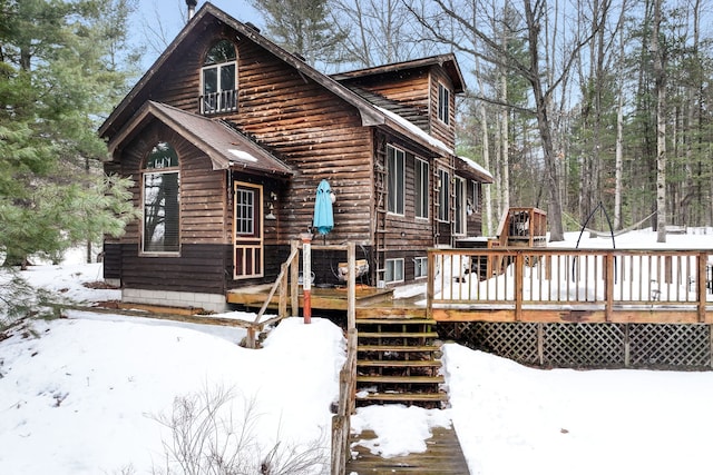 snow covered house featuring a deck