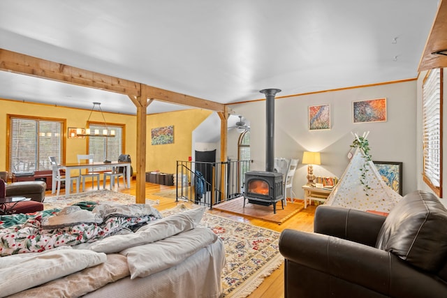 3232 5 Mile Rd, Traverse City, MI 49686 - living area with a wood stove, an inviting chandelier, and wood finished floors