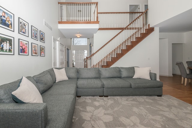 living room with hardwood / wood-style flooring and a high ceiling