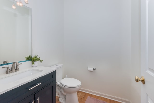 bathroom featuring toilet, vanity, and wood-type flooring