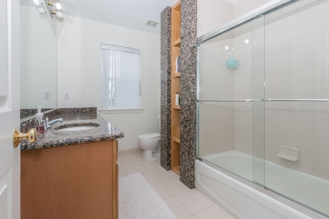 full bathroom featuring toilet, vanity, tile patterned flooring, and bath / shower combo with glass door