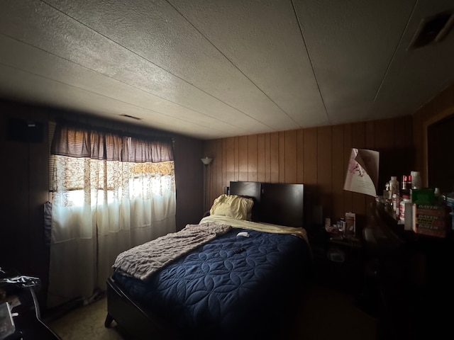 carpeted bedroom with wooden walls