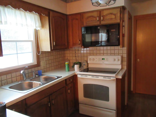 kitchen featuring sink, backsplash, and white electric stove