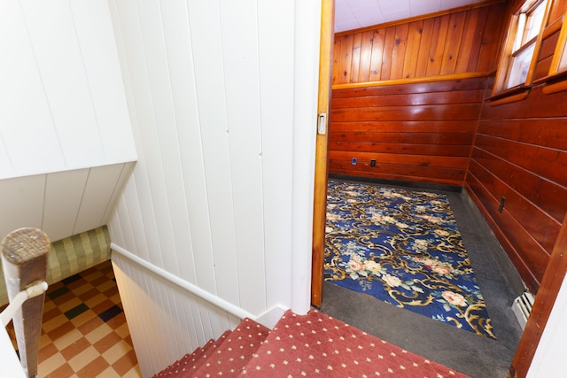 hallway with wooden walls and tile patterned floors