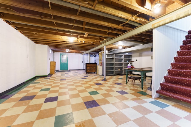 unfinished basement with light floors and stairway