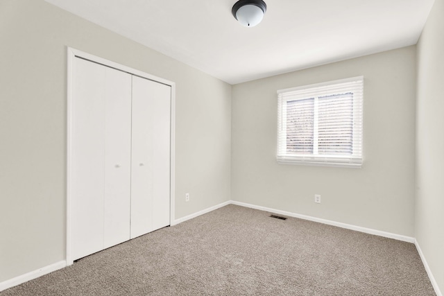 unfurnished bedroom featuring carpet floors and a closet