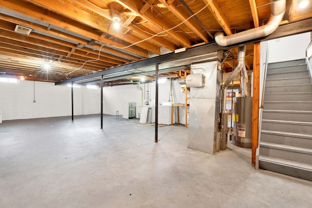 basement with water heater and washer and clothes dryer