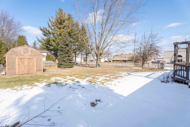 snowy yard with a storage shed