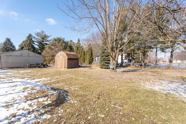 snowy yard with a storage shed