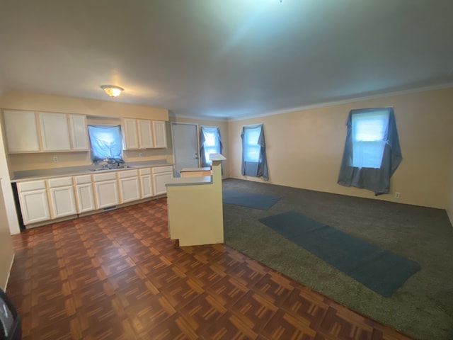 kitchen with white cabinets, sink, ornamental molding, and dark parquet floors