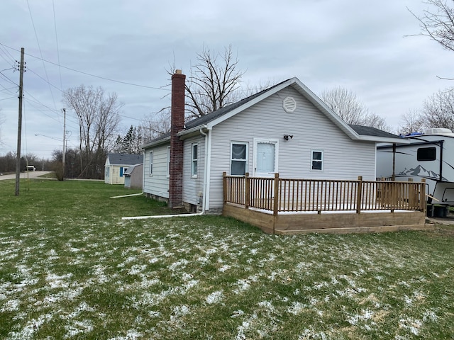 back of house featuring a lawn and a wooden deck