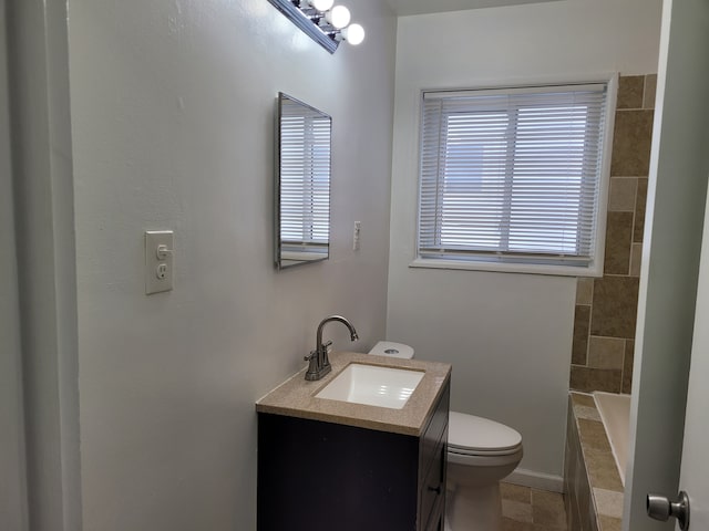 bathroom featuring vanity, toilet, and a tub