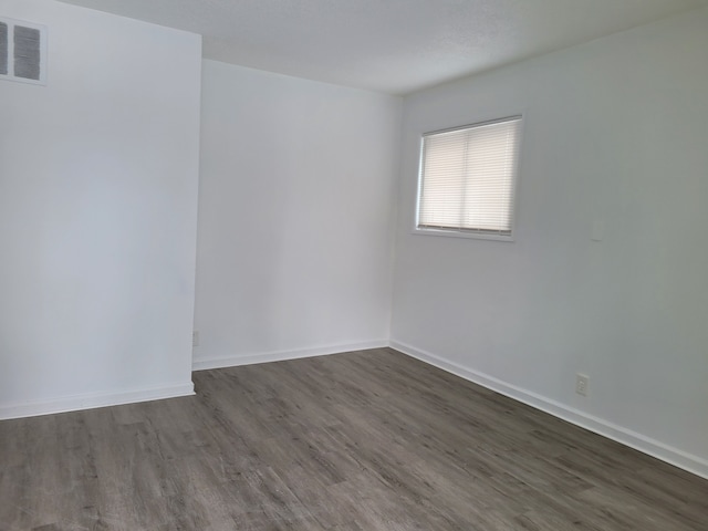 spare room with dark hardwood / wood-style flooring