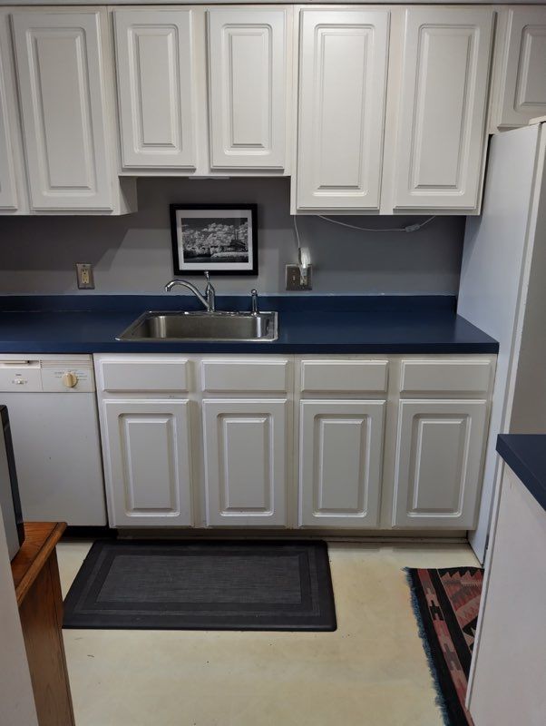 22673 Garrison St Unit 208, Dearborn, MI 48124 - kitchen with white cabinets, dishwasher, dark countertops, and a sink